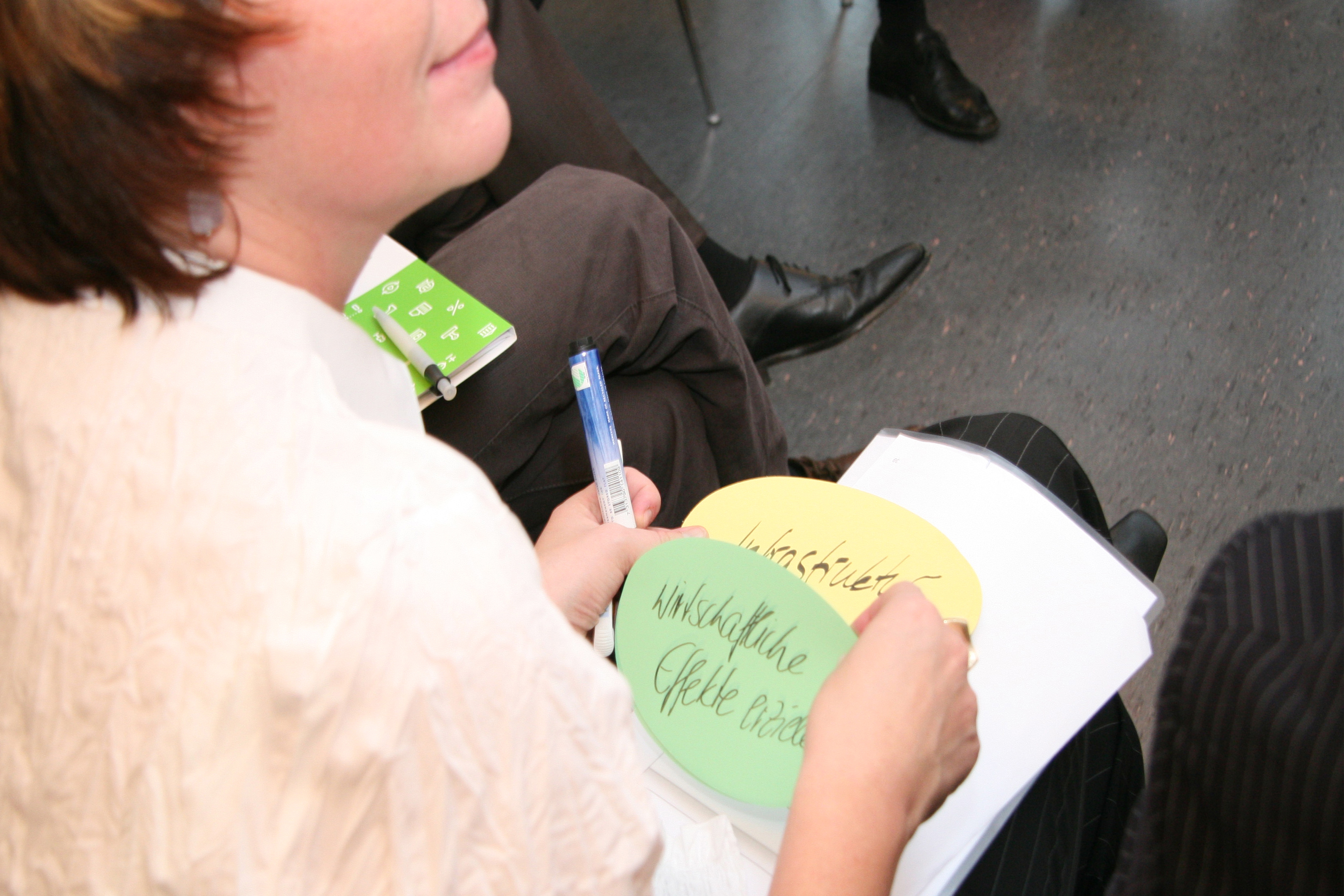 Moderationsteilnehmer hält Moderationskarten